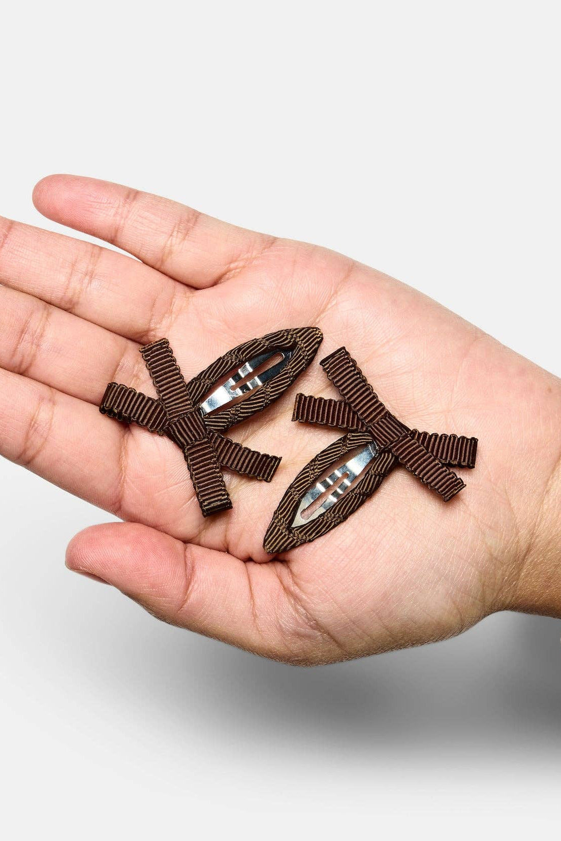 In Hand Chocolate Brown Bow Snap Clips by Chunks at Abacus Row Jewelry