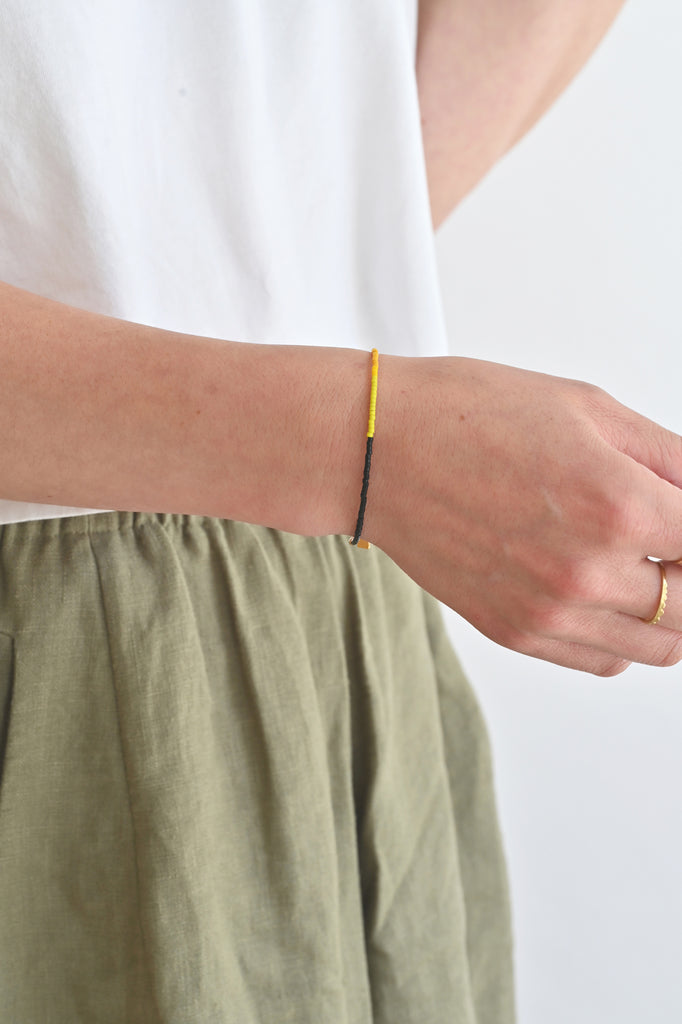 A Yellow Sun Bracelet styled on wrist at Abacus Row Handmade Jewelry