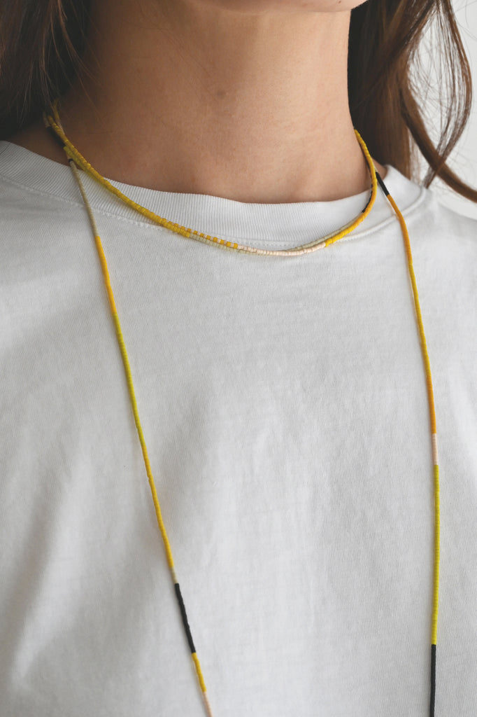 A Yellow Sun Necklace and wrap styled at Abacus Row Handmade Jewelry
