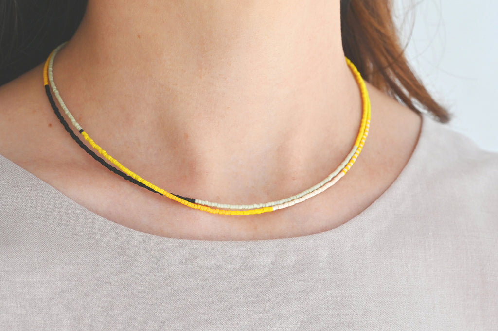 A Yellow Sun Necklace styled on model at Abacus Row Handmade Jewelry