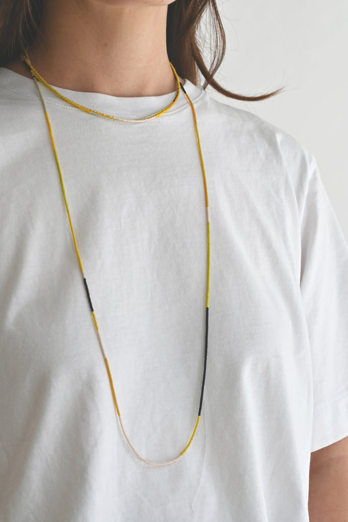 A Yellow Sun Wrap styled with necklace at Abacus Row Handmade Jewelry