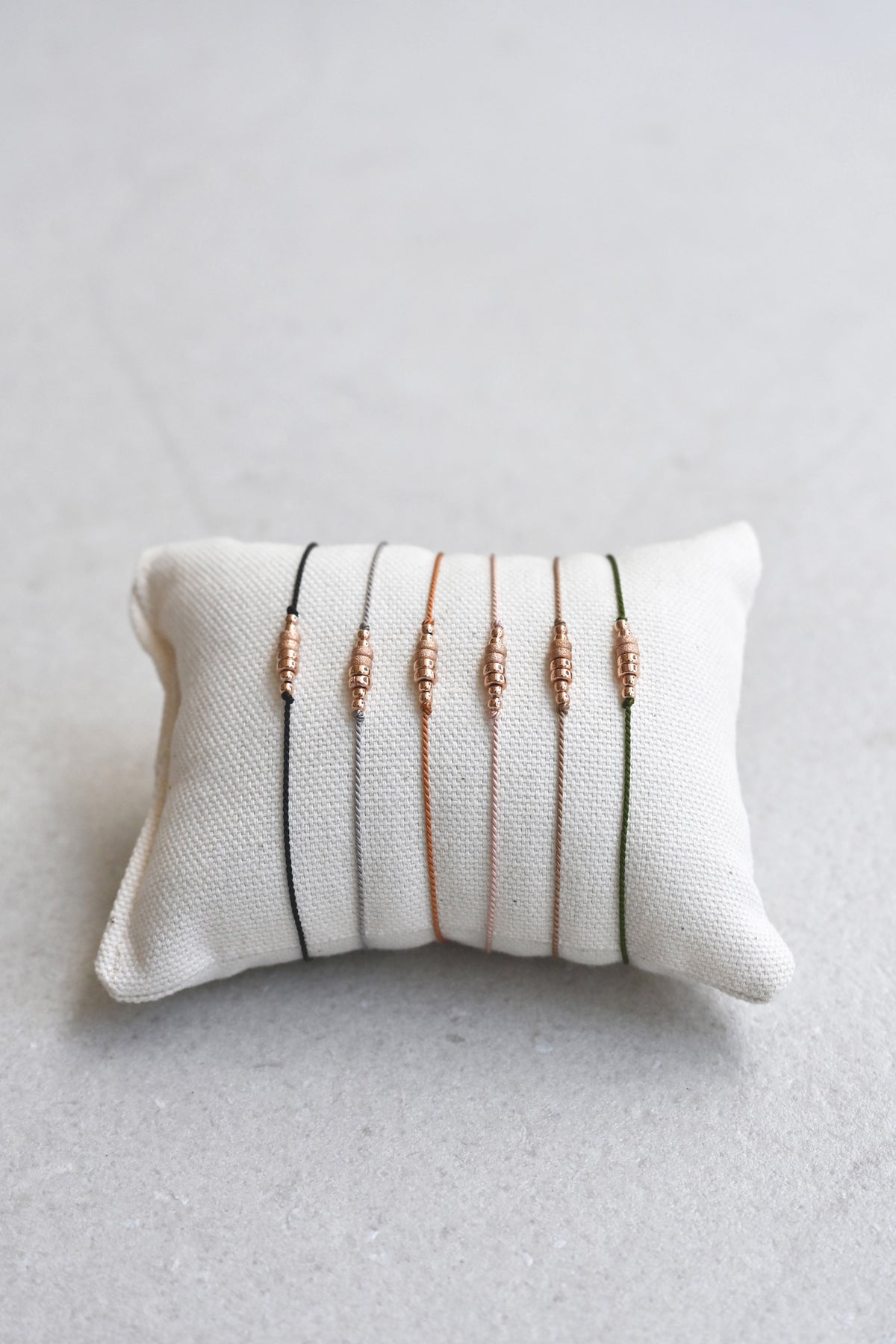 Friendship Bracelets No.5 on a pillow from Abacus Row Handmade Jewelry